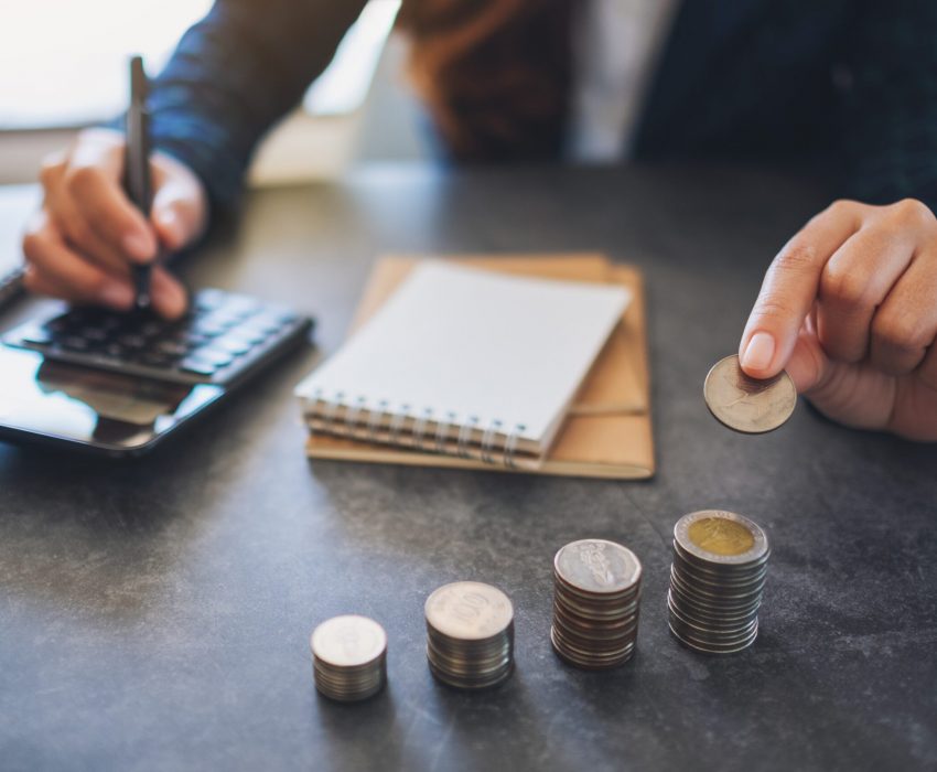 businesswoman-holding-and-stacking-coins-while-cal-2023-11-27-05-12-33-utc